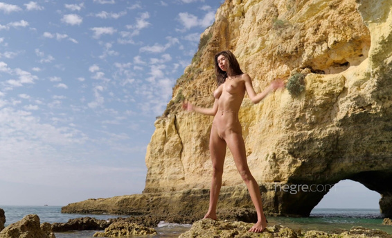 Худенькая фотомодель Анна красиво позирует обнаженной на диком пляже